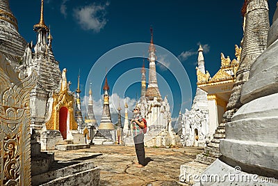 Woman traveling with backpack and looks at stupas Buddhist temple Stock Photo