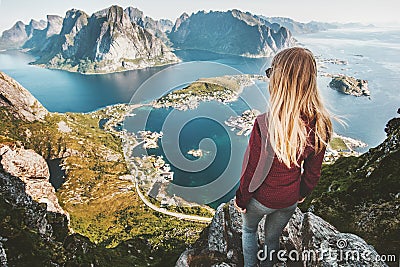 Woman traveling in Norway standing on cliff of Reinebringen mountain aerial view Stock Photo