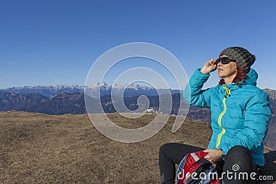 Woman trekker sunbathing in mountains Stock Photo