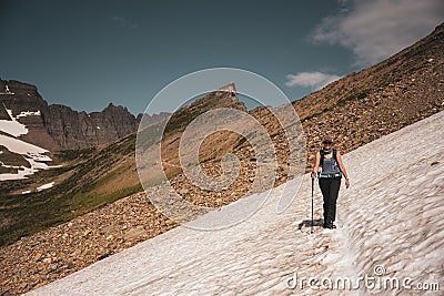 Woman treks across snowfield Stock Photo