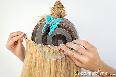 Woman tries on blonde remy clip natural hair extension clips Stock Photo