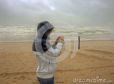 Woman tries to take a picture during a severe tempest hits the coast near Noordwijk town Editorial Stock Photo