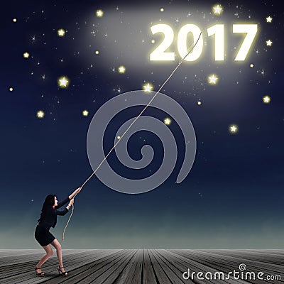 Woman try to get number 2017 Stock Photo