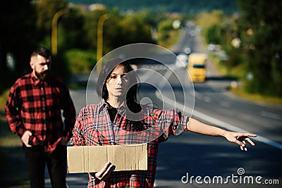 Woman try to stop car with blank cardboard sign Stock Photo