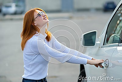A woman trying to open closed car doors Stock Photo