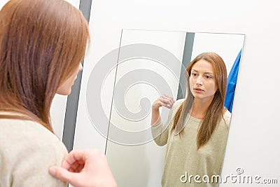 Woman trying top in fitting room Stock Photo