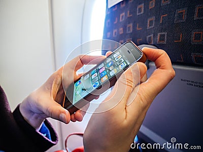 Woman turning off her mobile phone smartphone plane aircraft Editorial Stock Photo