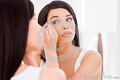 Woman tweezing eyebrows. Stock Photo