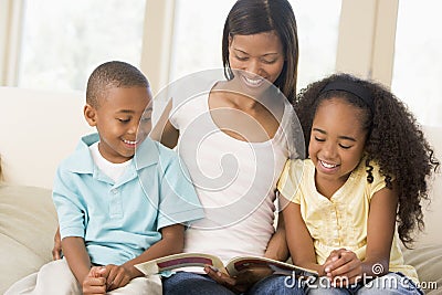 Woman and two children sitting in living room Stock Photo