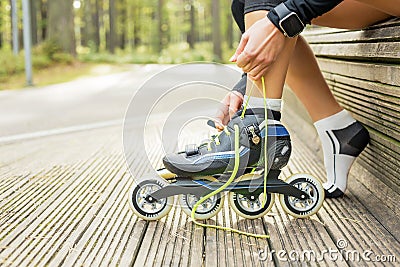 Woman tying roller skates Stock Photo