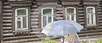 Woman with an umbrella. An old house from the times of the Russian Empire in the center of the city of Penza. Stock Photo