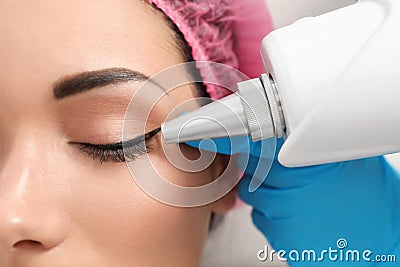 Woman undergoing laser tattoo removal procedure in salon Stock Photo