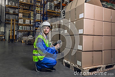 Woman in uniform holding device crouching Stock Photo