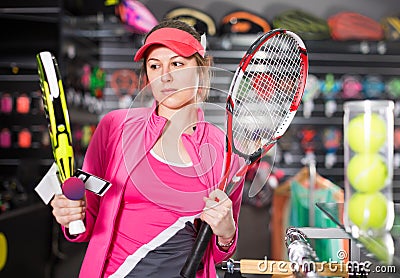 Woman in uniform is holding new racket for padel and tennis in the store Stock Photo