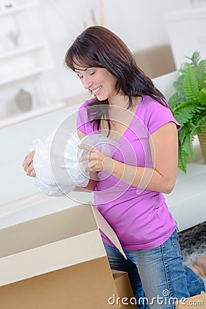 woman unpacking possessions from cardboard box Stock Photo