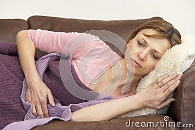 Woman Unwell And Lying On Sofa Stock Photo