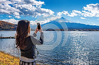 Woman use mobile phone take a photo at Fuji mountains, Kawaguchiko lake in Japan Stock Photo