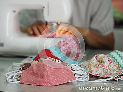 Woman use sew machine to sewing face medical mask protective against during the dust PM 2.5, coronavirus Epidemic, virus covid-19 Stock Photo