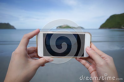Woman use smart phone take a photo of the sea in Prachuapkhirikhan ,thailand real picture in monitor Stock Photo