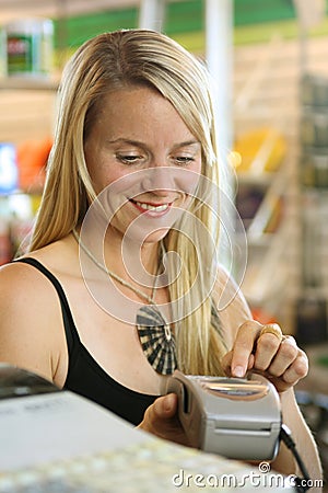 Woman using debit terminal Stock Photo