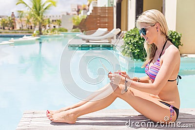 Woman using digital tablet by the pool Stock Photo