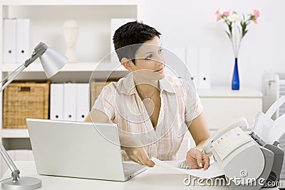 Woman using fax machine Stock Photo
