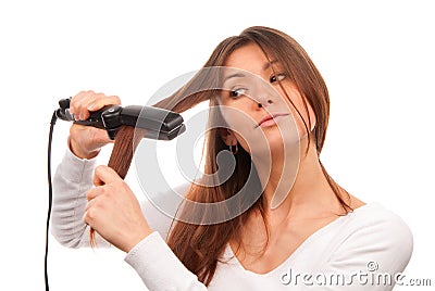 Woman using hair straighteners for hairstyle Stock Photo