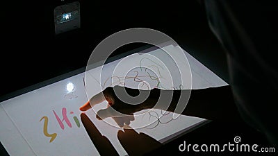 Woman using interactive touchscreen projector display for drawing Stock Photo