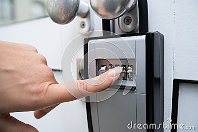 Woman Using Key Safe To Retrieve Keys Stock Photo