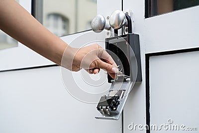 Woman Using Key Safe To Retrieve Keys Stock Photo