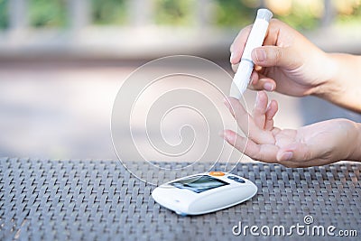 Woman using lancet on finger to check blood sugar level Stock Photo