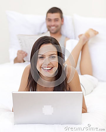 Woman using a laptop and man reading a new Stock Photo