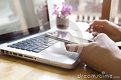 Woman using laptop and mobile phone to online shopping and pay by credit card. Stock Photo