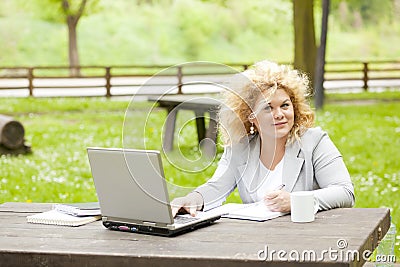 Woman using laptop in park Stock Photo