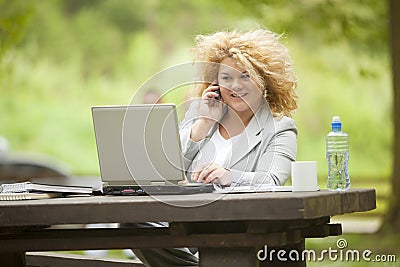 Woman using laptop in park Stock Photo