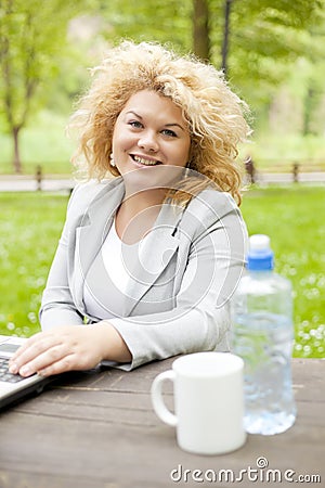 Woman using laptop in park Stock Photo