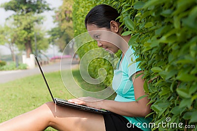 Woman using laptop in the park Stock Photo