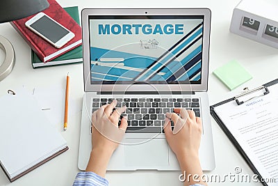 Woman using laptop to pay Mortgage loan online in office Editorial Stock Photo