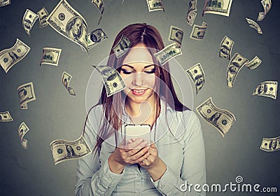 Woman using looking at her smart phone under money rain Stock Photo