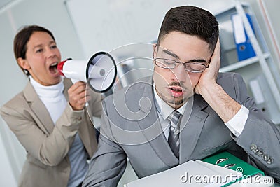 Woman using loudhailer to wake businessman Stock Photo