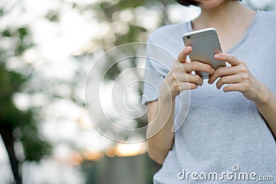 Woman using mobile smart phone in the park Editorial Stock Photo