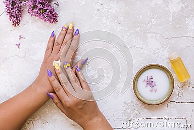 Beautiful woman putting lilac cream on her hand Stock Photo