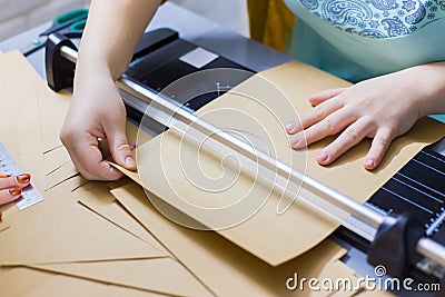 Woman using paper cutter, guillotine Stock Photo