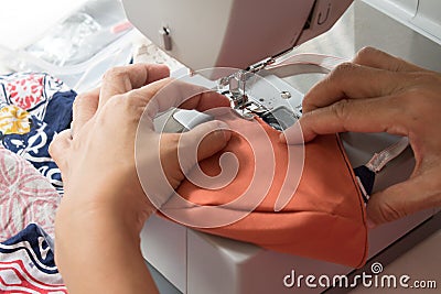 Woman using the sewing machine to making the fabric mask Stock Photo