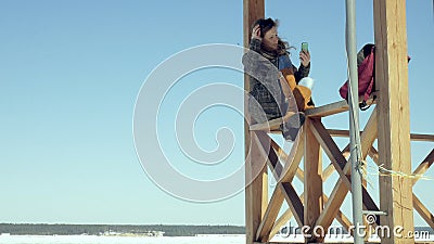 Woman Using Smartphone Relaxes on the Bench in Beautiful Park. Young Woman in making gestures on Phone Display Stock Photo