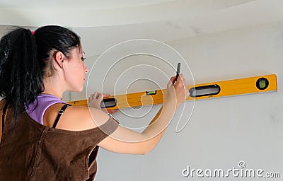 Woman using a spirit level while renovating Stock Photo