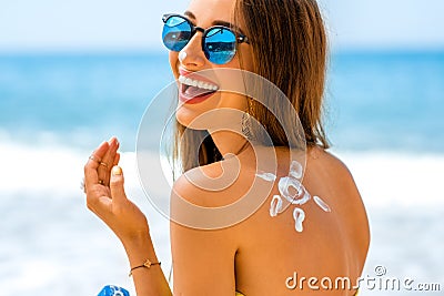 Woman using sun cream on the beach Stock Photo