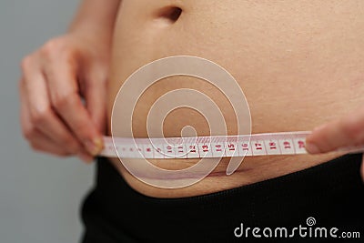 woman using tape measuring the c-section scar of cesarean on belly Stock Photo