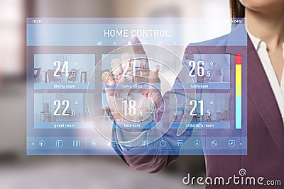 Woman using touchscreen panel to set indoor temperature. Smart home automation system Stock Photo