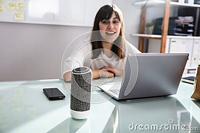 Woman Using Voice Assistant In Office Stock Photo